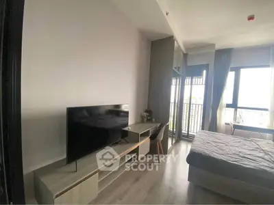 Modern bedroom with balcony and sleek furniture, featuring a large TV and stylish decor.