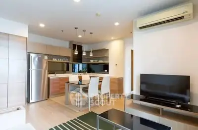 Modern open-layout kitchen and living room with sleek appliances and stylish decor.