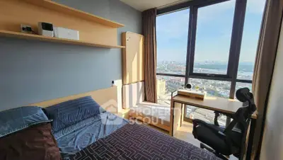Modern bedroom with stunning city view, featuring a cozy bed, desk, and large window for natural light.