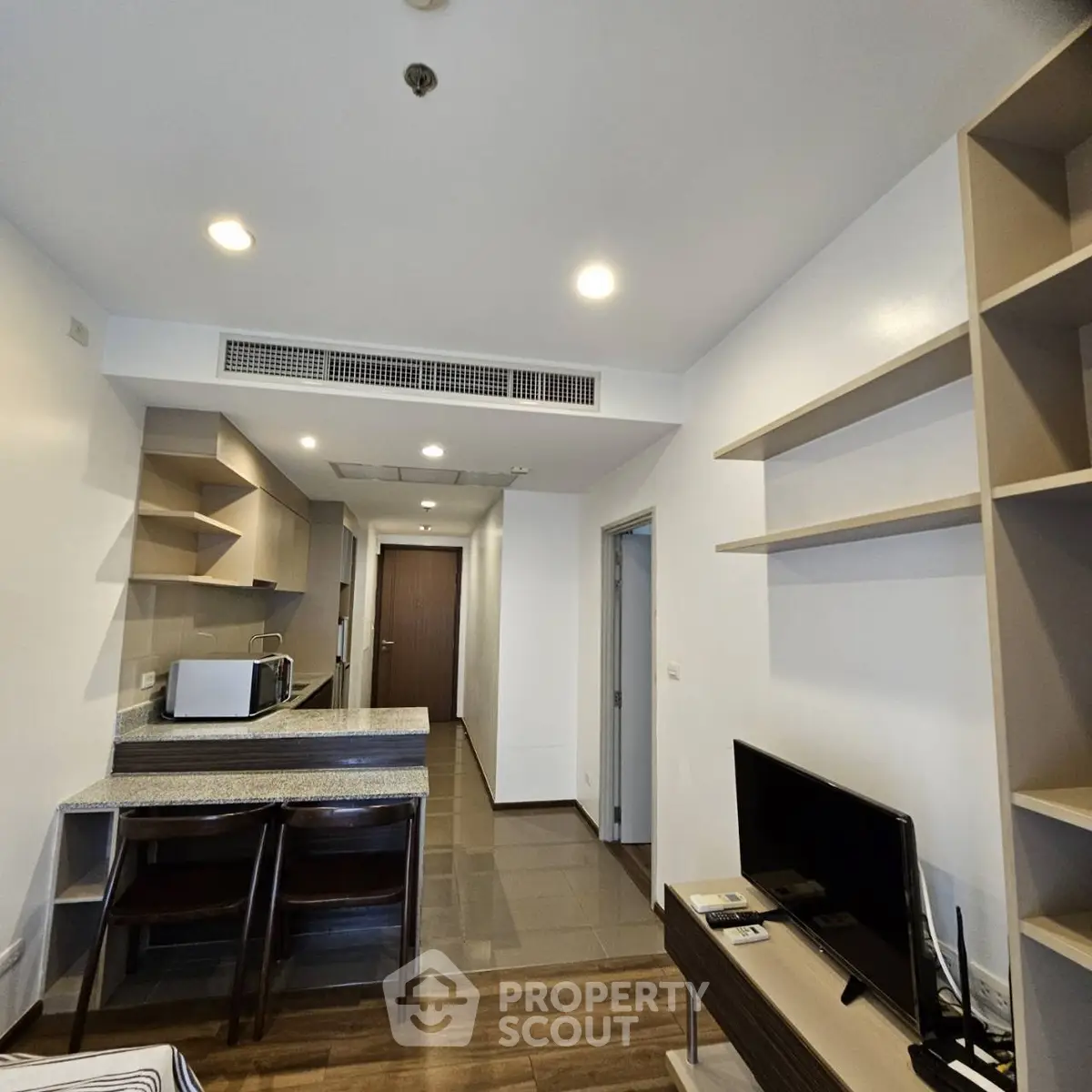 Modern open-layout living room with integrated kitchen and stylish shelving