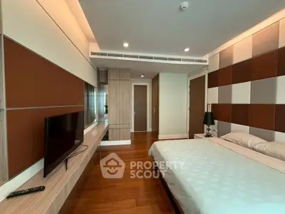 Modern bedroom with stylish wood paneling and sleek TV setup