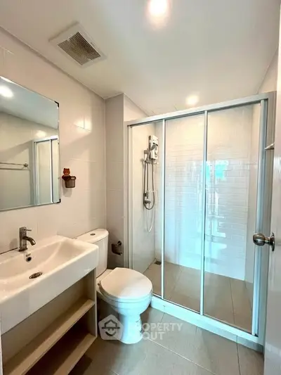 Modern bathroom with glass shower and sleek fixtures in a contemporary home.