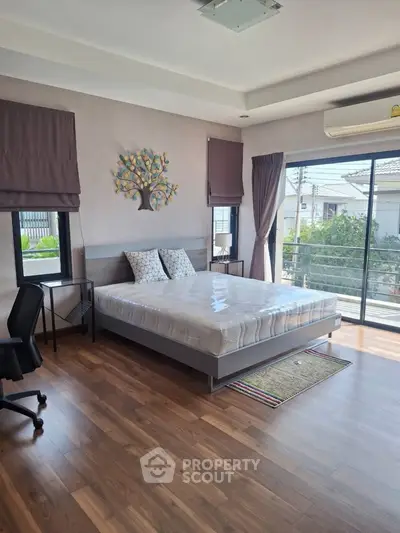 Spacious bedroom with modern decor and balcony access in a stylish home.