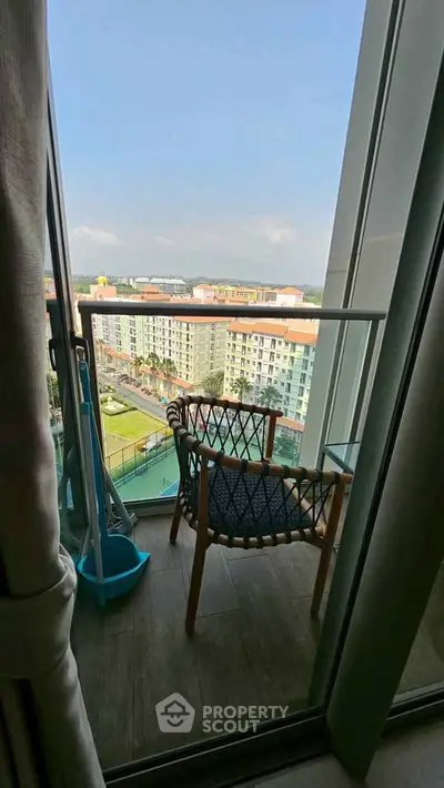 Charming balcony with cozy seating and stunning city view, perfect for relaxation and enjoying the outdoors.