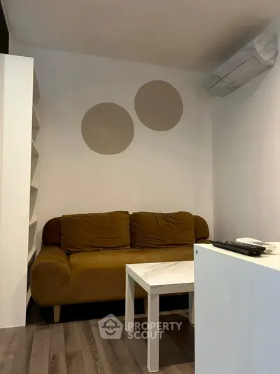 Cozy living room with modern sofa and air conditioning, perfect for relaxation.