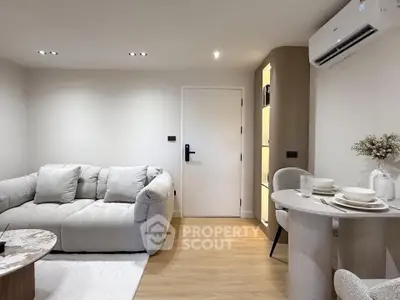 Modern living room with cozy sofa and dining area, featuring minimalist decor and soft lighting.