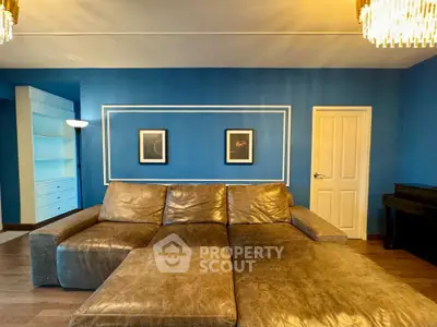 Spacious living room with luxurious leather sofa and elegant blue walls.