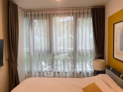 Cozy bedroom with large windows and elegant curtains, perfect for natural light lovers.