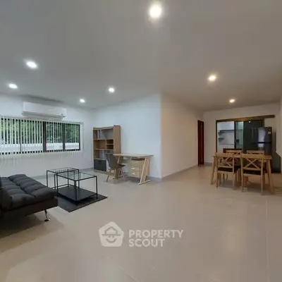 Spacious open-plan living room with modern furniture and dining area