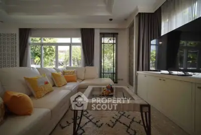 Spacious living room with large windows and modern decor, featuring a cozy sectional sofa and stylish coffee table.