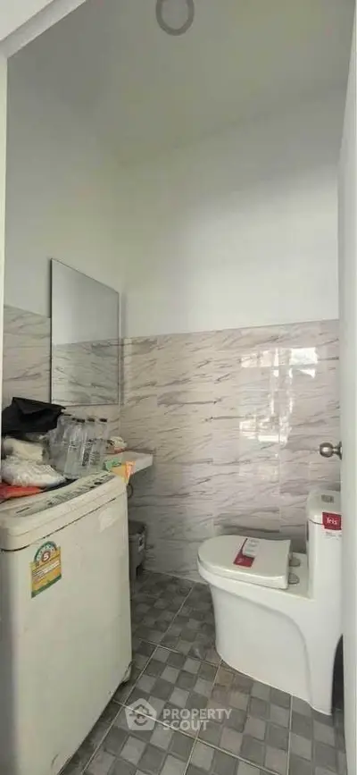 Compact bathroom with modern fixtures and tiled walls, ideal for small spaces.