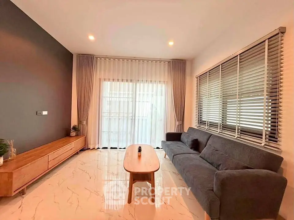 Modern living room with sleek furniture and large windows for natural light.