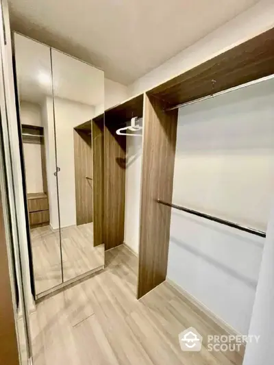 Spacious walk-in closet with modern wooden finish and ample storage space.