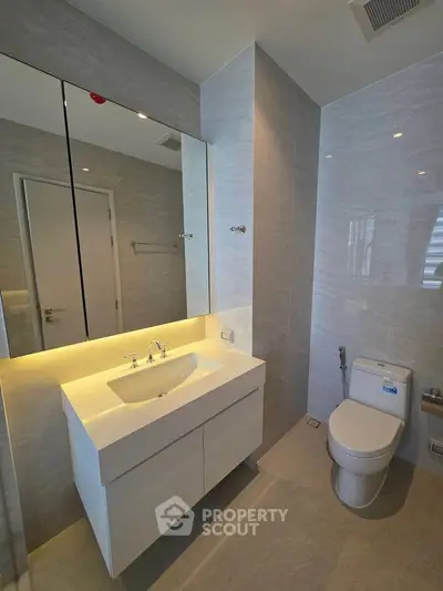 Modern bathroom with sleek vanity and toilet in a contemporary apartment.
