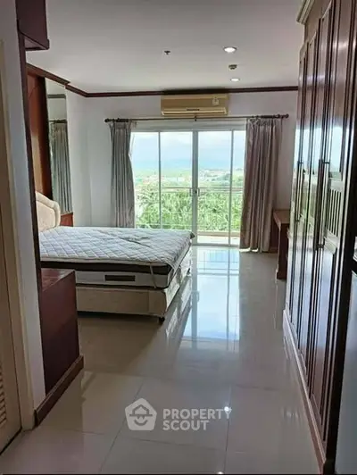 Spacious bedroom with large windows offering stunning views and ample natural light.