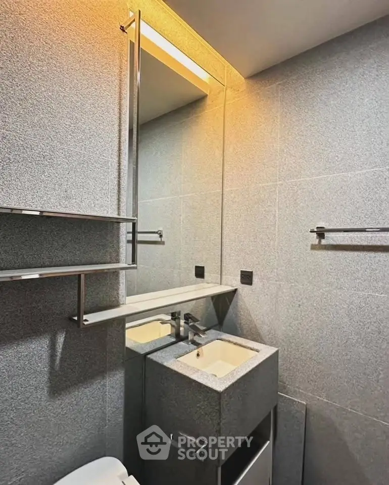 Modern bathroom with sleek design and elegant fixtures, featuring a stylish vanity and ambient lighting.