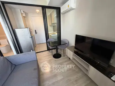Modern compact living room with open kitchen and sleek furniture in a stylish apartment.