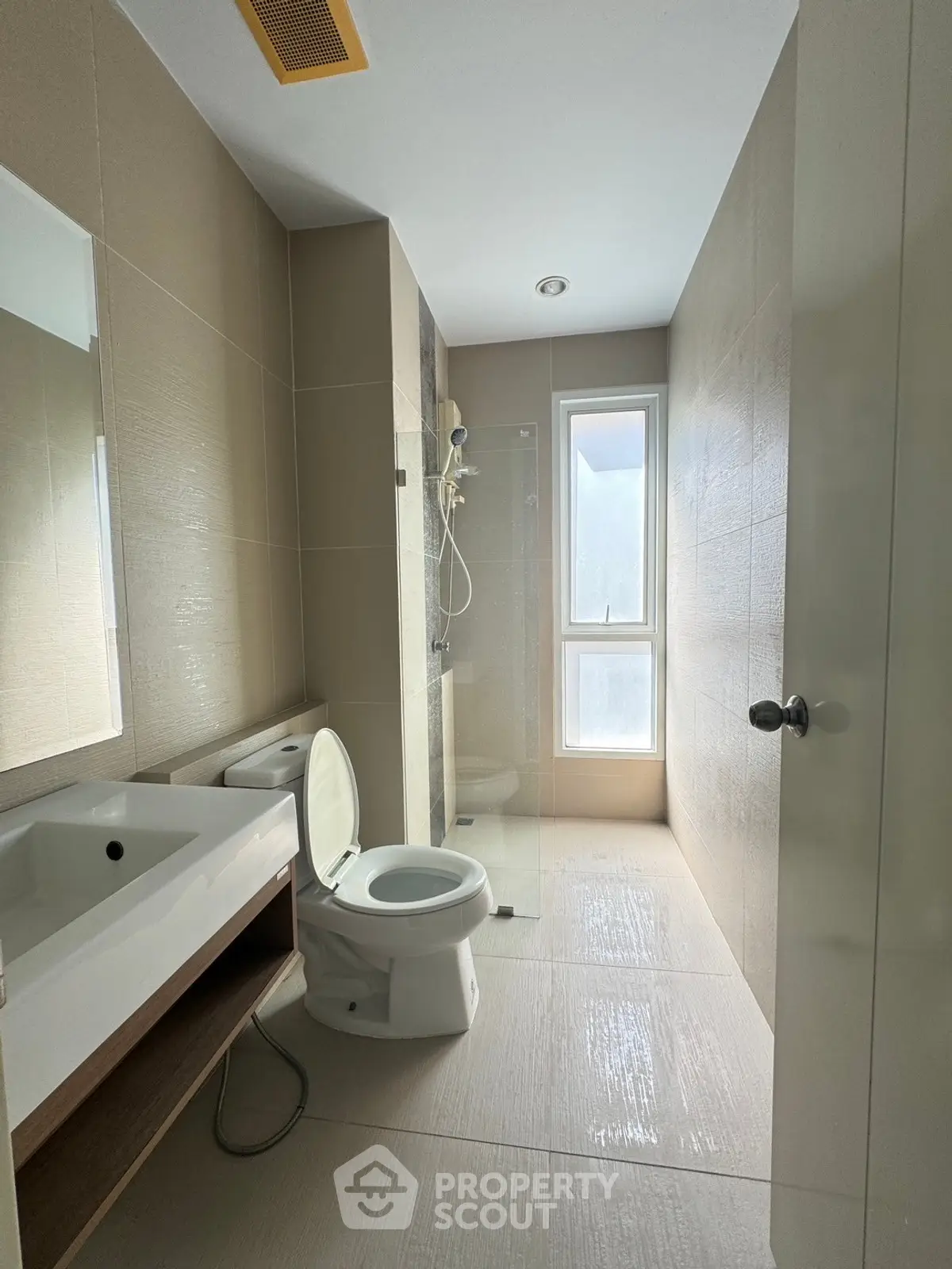 Modern bathroom with sleek design, featuring a glass shower and natural light.