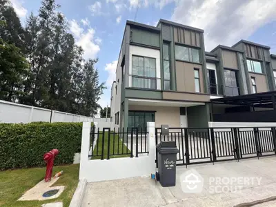 Modern townhouse exterior with sleek design and gated entrance in a serene neighborhood.