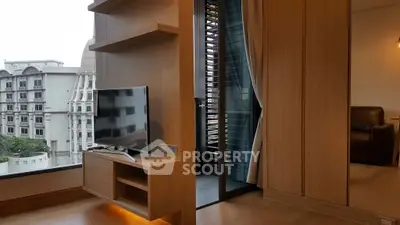 Modern living room with sleek TV unit and balcony view in luxury apartment
