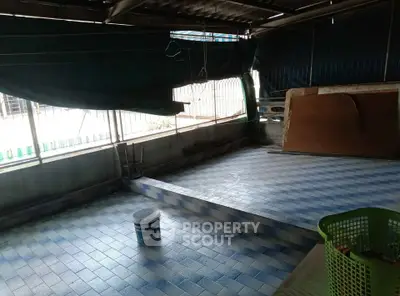 Spacious tiled area with natural light, ideal for versatile use in real estate property.