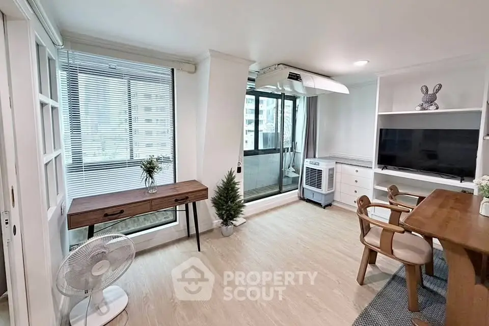 Modern living room with balcony, stylish furniture, and natural light