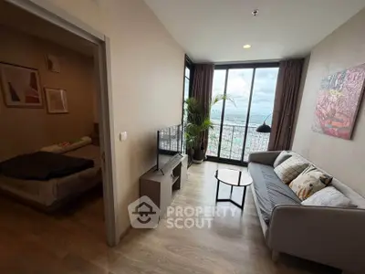 Modern living room with city view, cozy sofa, and stylish decor in high-rise apartment.