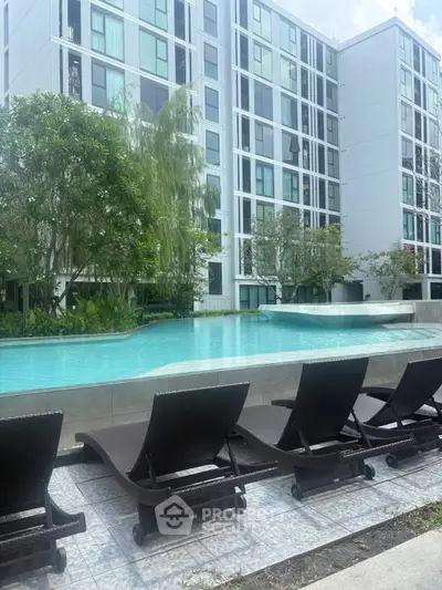Luxurious apartment complex with serene poolside view and modern architecture.