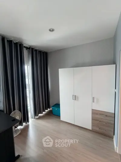 Spacious bedroom with modern wardrobe and large window for natural light