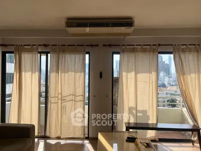 Spacious living room with large windows and city view, perfect for natural light lovers.