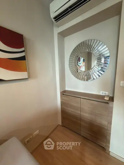 Stylish interior corner with modern mirror and artwork, perfect for contemporary living spaces.
