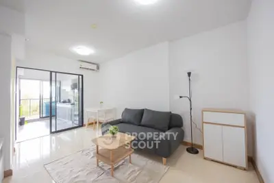 Modern living room with sleek furniture and open balcony view, perfect for urban living.