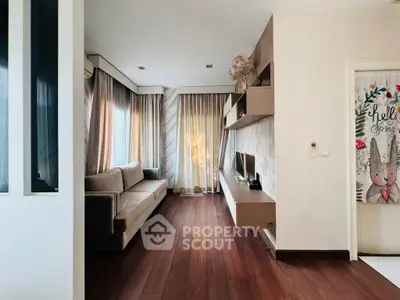 Modern living room with sleek design and natural light, featuring a cozy sofa and stylish TV unit.