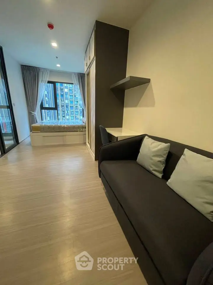 Modern studio apartment with cozy living area and large window view