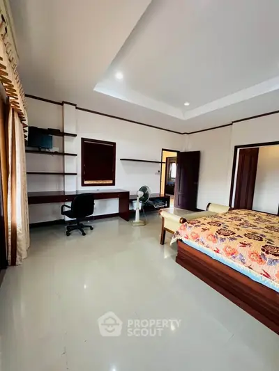 Spacious bedroom with modern furnishings and natural light, ideal for comfort and relaxation.