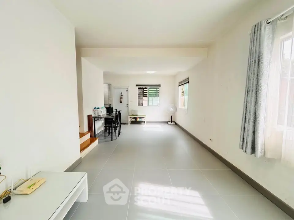 Spacious living room with modern decor and large windows for natural light.