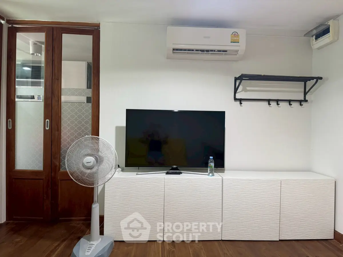 Modern living room with air conditioning, TV, and stylish storage unit