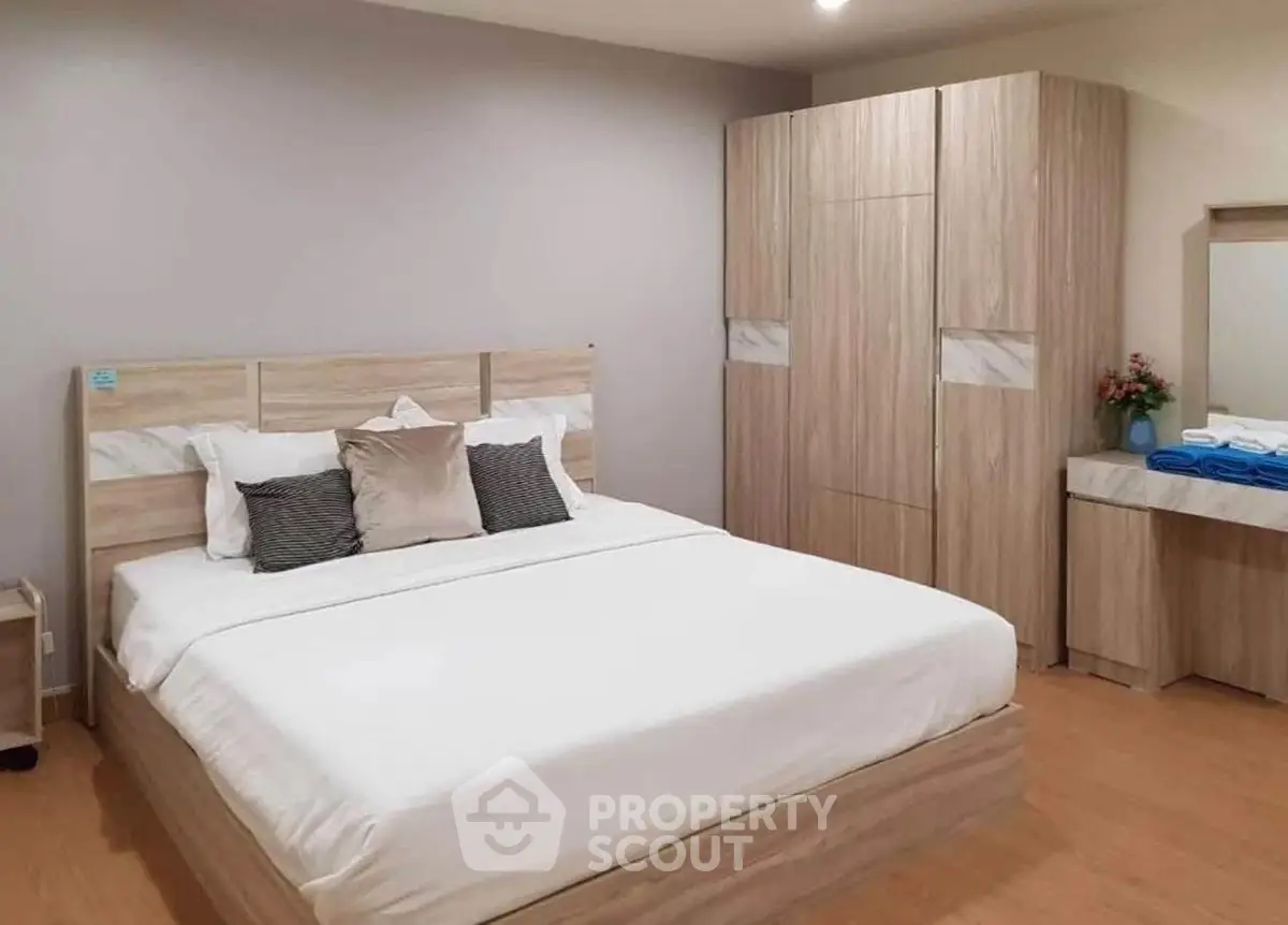 Spacious bedroom with modern wooden furniture and cozy bedding