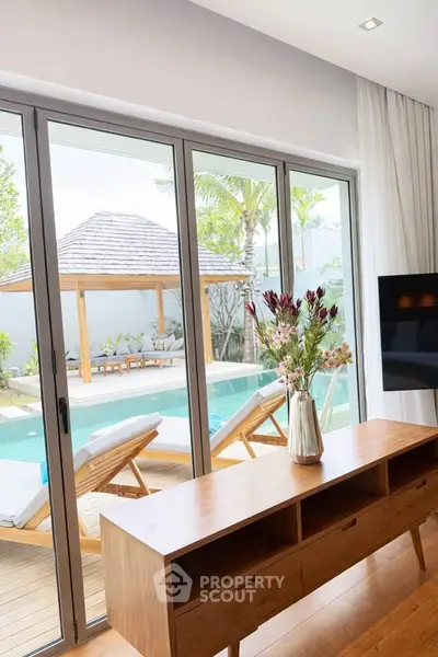 Luxurious living room with poolside view and elegant wooden furniture