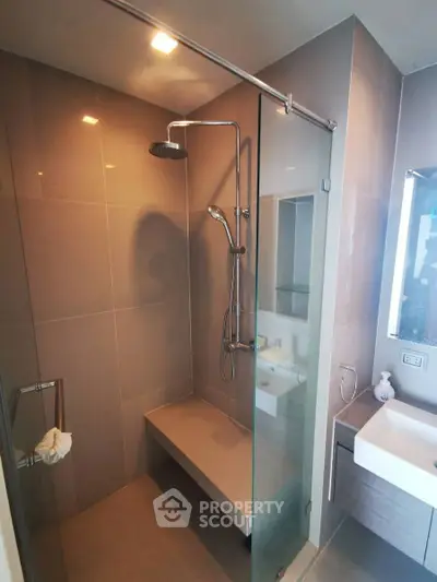 Modern bathroom with sleek shower and contemporary fixtures in luxury apartment.