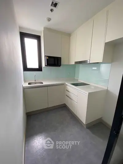 Modern compact kitchen with sleek cabinetry and built-in appliances in a minimalist design.