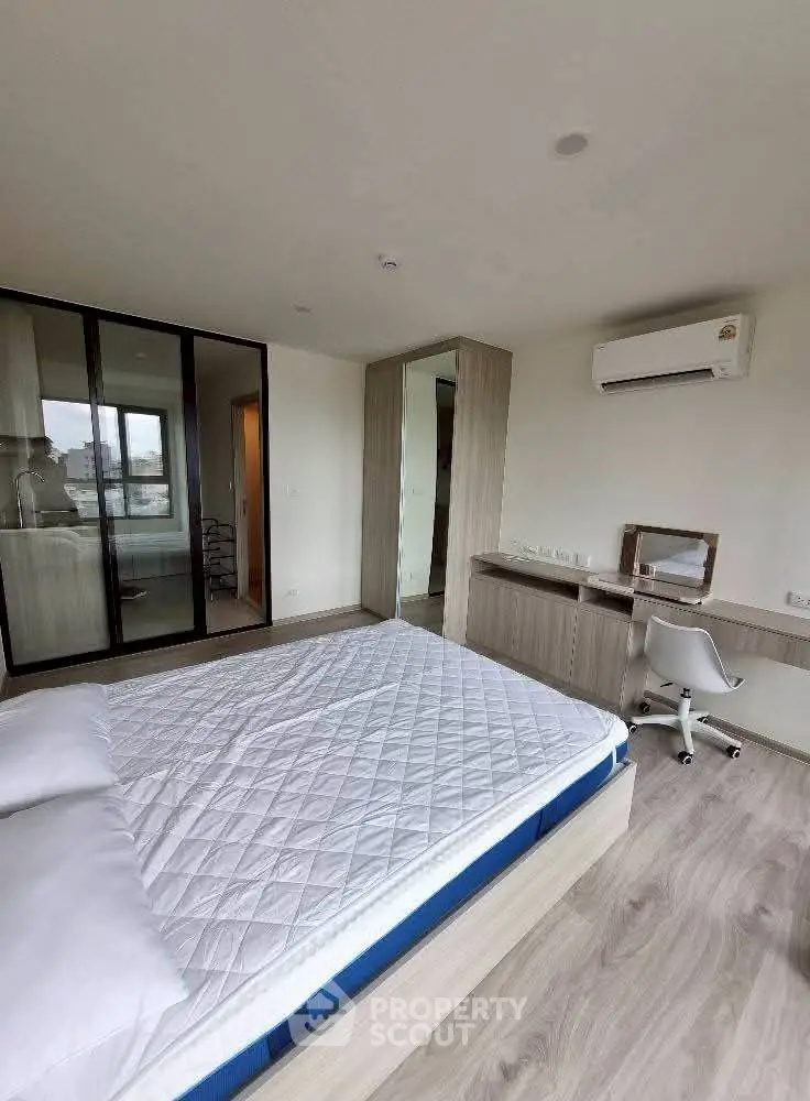 Modern bedroom with sleek design, featuring a built-in wardrobe and air conditioning.