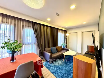 Modern living room with stylish decor, featuring a cozy sofa, vibrant rug, and elegant dining area.