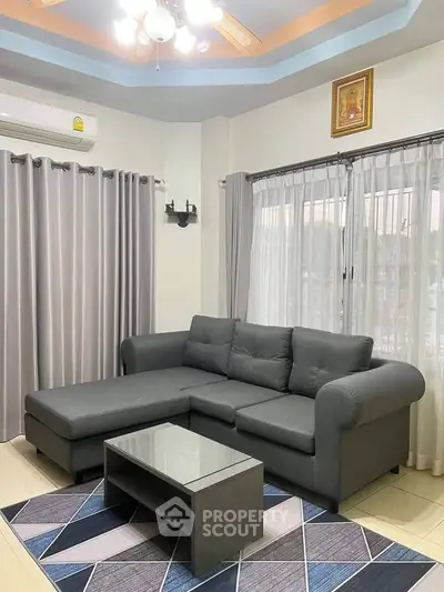 Modern living room with stylish gray sectional sofa and chic geometric rug.