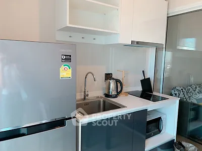 Modern kitchen with sleek appliances and stylish cabinetry in a contemporary apartment.