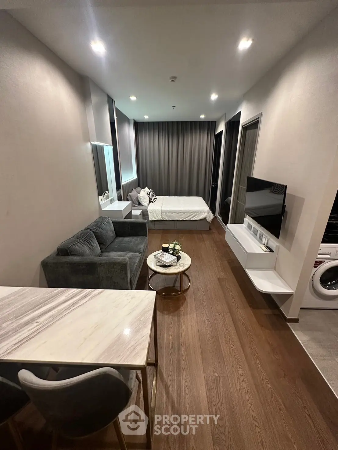 Modern studio apartment with sleek design, featuring a cozy living area, stylish furniture, and integrated appliances.