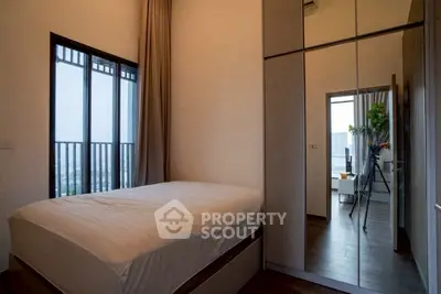 Modern bedroom with large mirrored wardrobe and city view balcony.