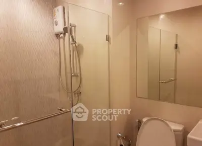 Modern bathroom with glass shower and large mirror in sleek design.