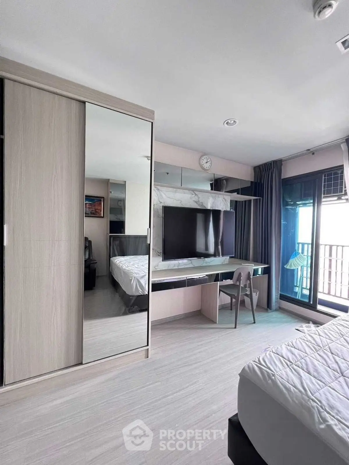 Modern bedroom with mirrored wardrobe and balcony access