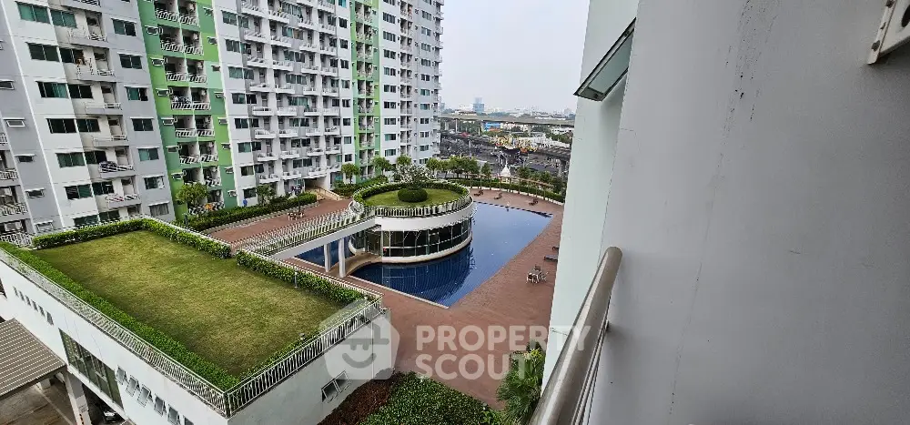 Modern residential complex with pool and garden view from balcony
